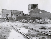 A brick warehouse destroyed near the railroad tracks.